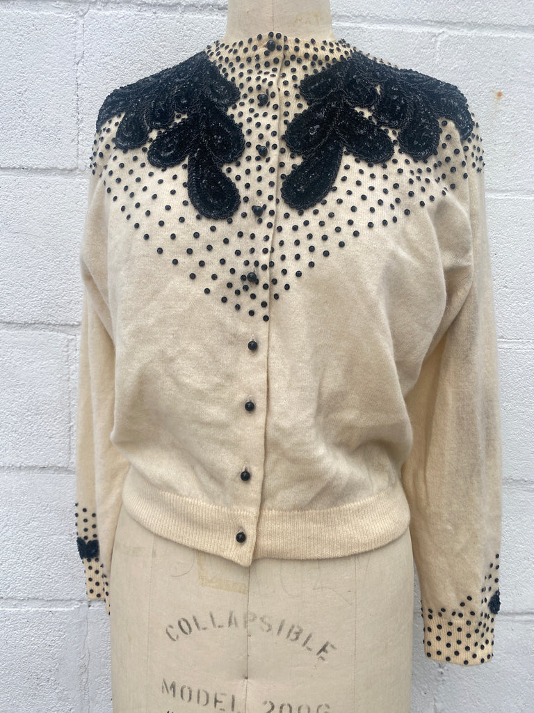 1950s vintage cream color Cashmere button up cardigan sweater with hand beaded black beads,  sequins, and beaded appliqué on the shoulders and wrists.  Size Small / Medium